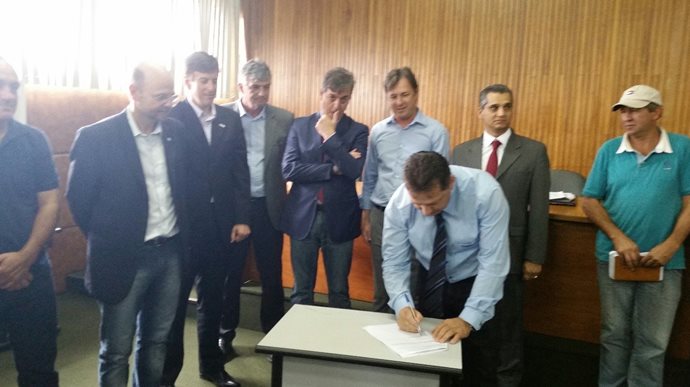 Milton Racho assinando o termo de compromisso